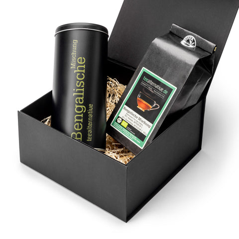 Offene schwarze Geschenkbox mit Teedose und Teebeutelpackung, farbige Etiketten sichtbar