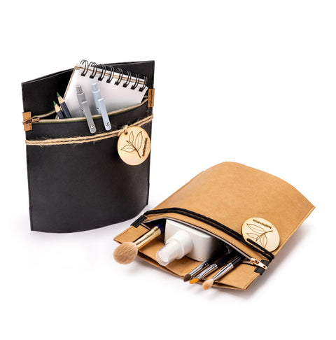 Schwarze Geschenktasche aus Filz, offen mit Ringbuch und Kosmetikartikeln im Fach
