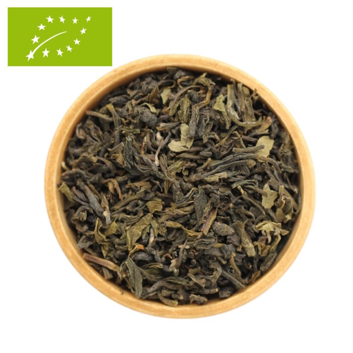 Eine Holzschale, gefüllt mit getrockneten, biologischen Darjeeling Grünteeblättern